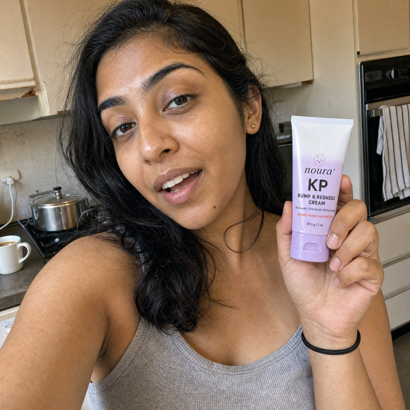 Woman in her kitchen holding up a tube of Noura cream